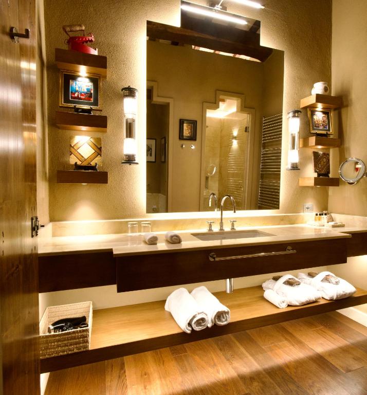 a bathroom with a sink and a large mirror at L'Olmo in Monticchiello
