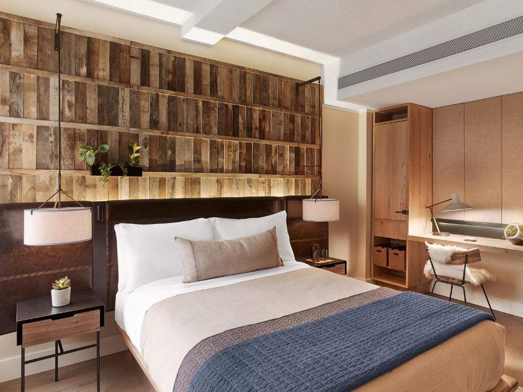 a bedroom with a bed and a wall with reclaimed wood at 1 Hotel Central Park in New York