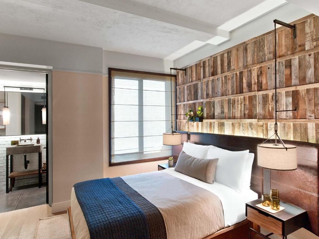 a bedroom with a bed and a large window at 1 Hotel Central Park in New York