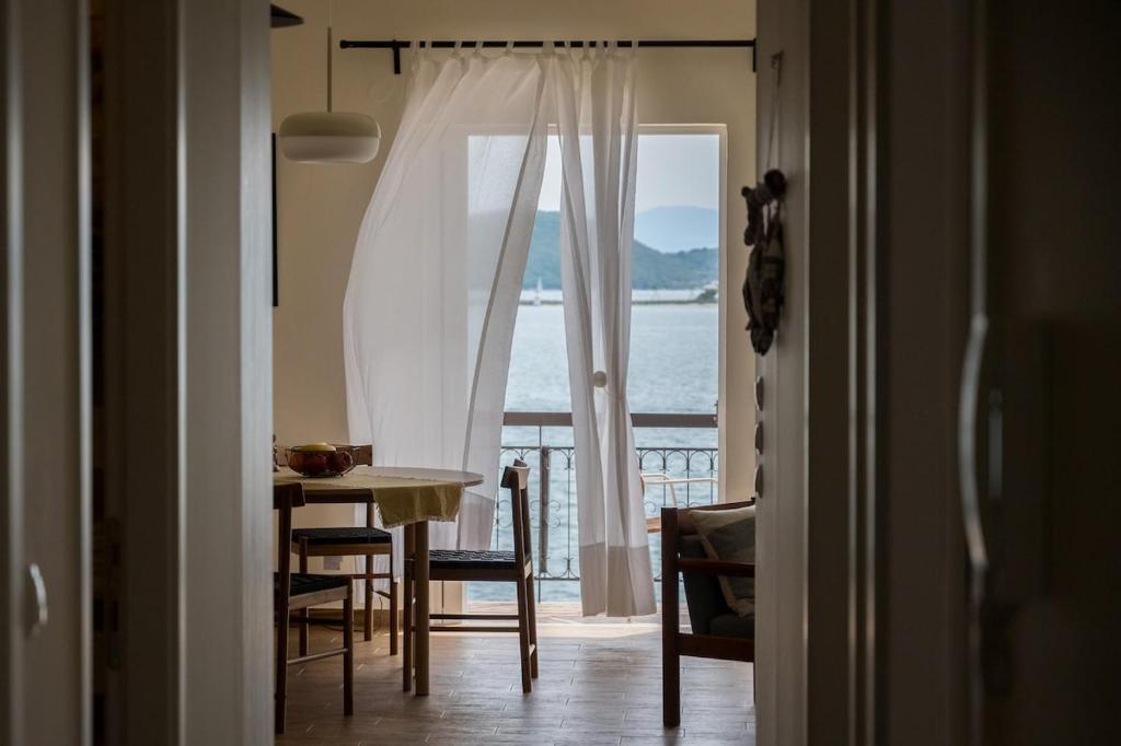 een kamer met een tafel en uitzicht op de oceaan bij Finestrini in Preveza