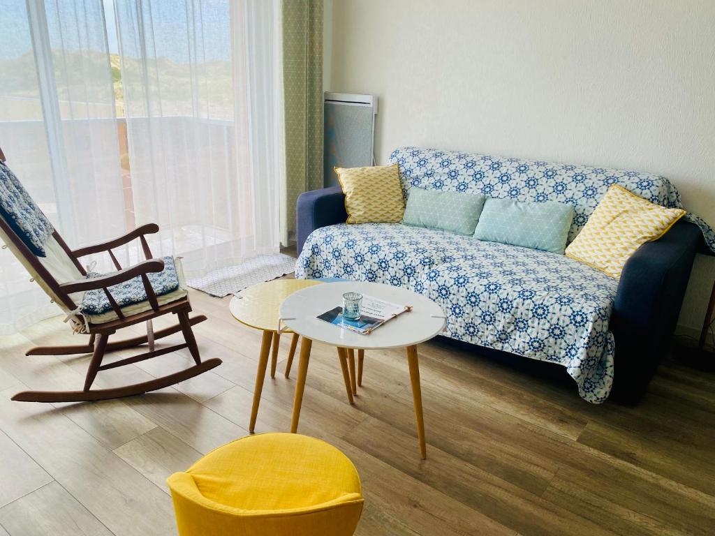 - un salon avec un canapé et une chaise dans l'établissement La Timonerie - La Caraque 35, vue mer et dunes classé 2 étoiles, à Fort-Mahon-Plage