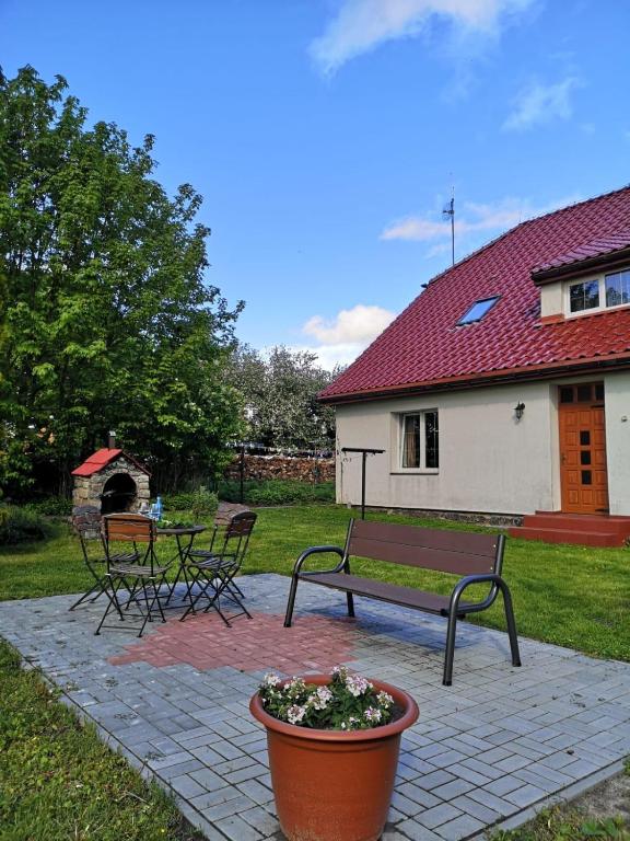 a patio with a bench and a potted plant at Agroturystyka Pod Podkową in Darłowo