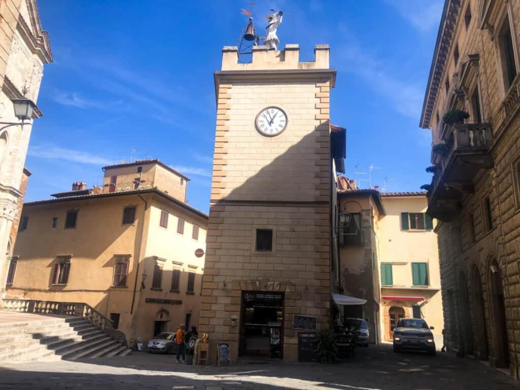 a clock tower with a statue on top of it at La dimora Poliziana di Anna in Montepulciano