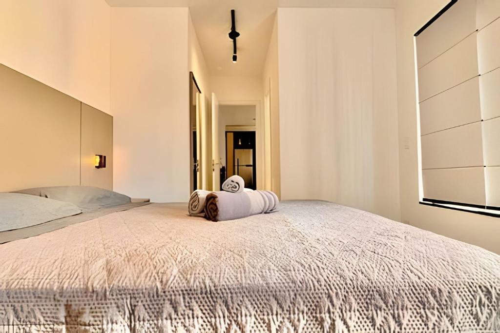 a bedroom with a large bed with white sheets at Incrivel, Apto 1 Quarto Bem Prox Batel in Curitiba