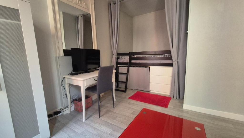 Cette petite chambre comprend un bureau et une télévision. dans l'établissement Appartement vieille ville Le Puy, au Puy-en-Velay