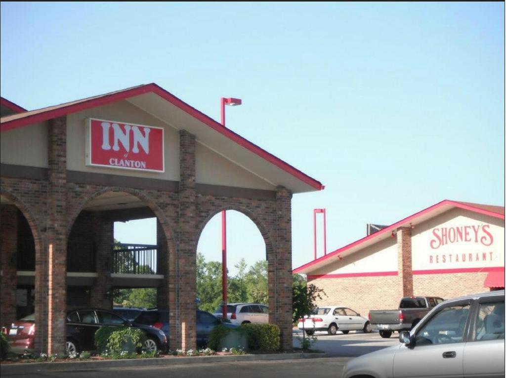 a fast food restaurant with cars parked in a parking lot at Inn of Clanton in Clanton