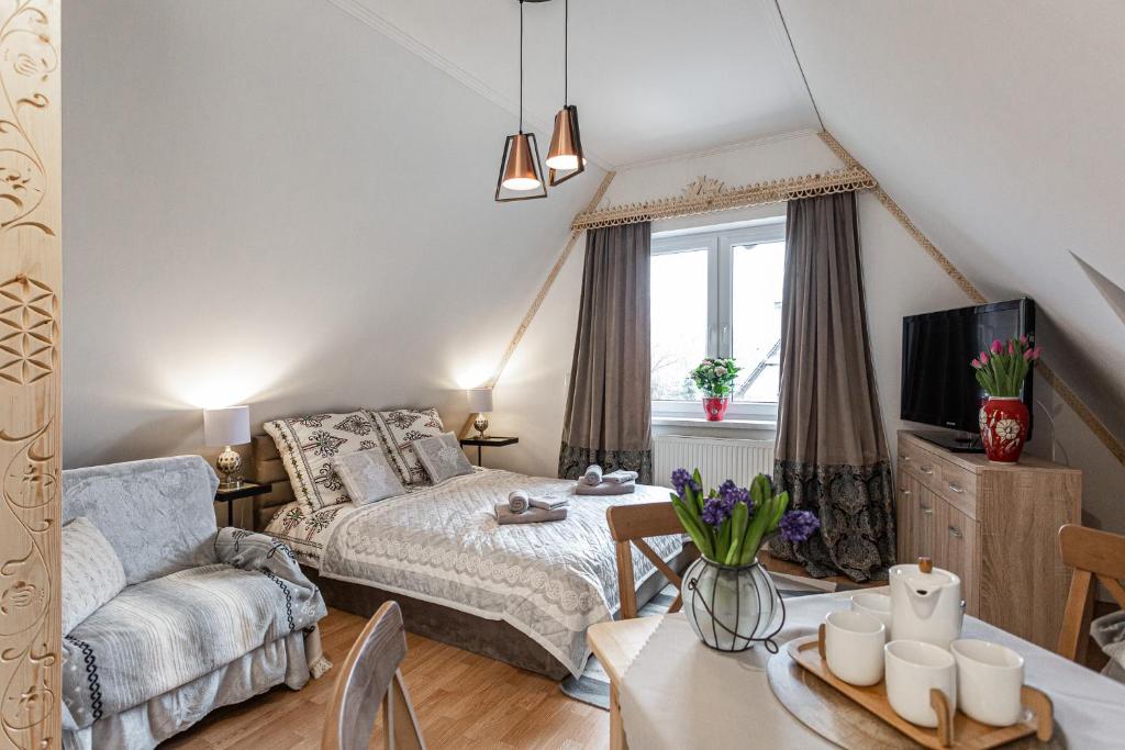 a bedroom with a bed and a living room with a table at My Mountain View in Zakopane