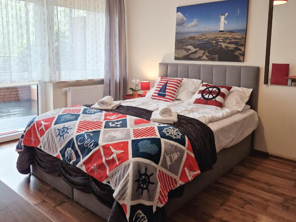 a bedroom with a bed with a quilt on it at Apartament TRZY POMOSTY Villa Mistral in Świnoujście