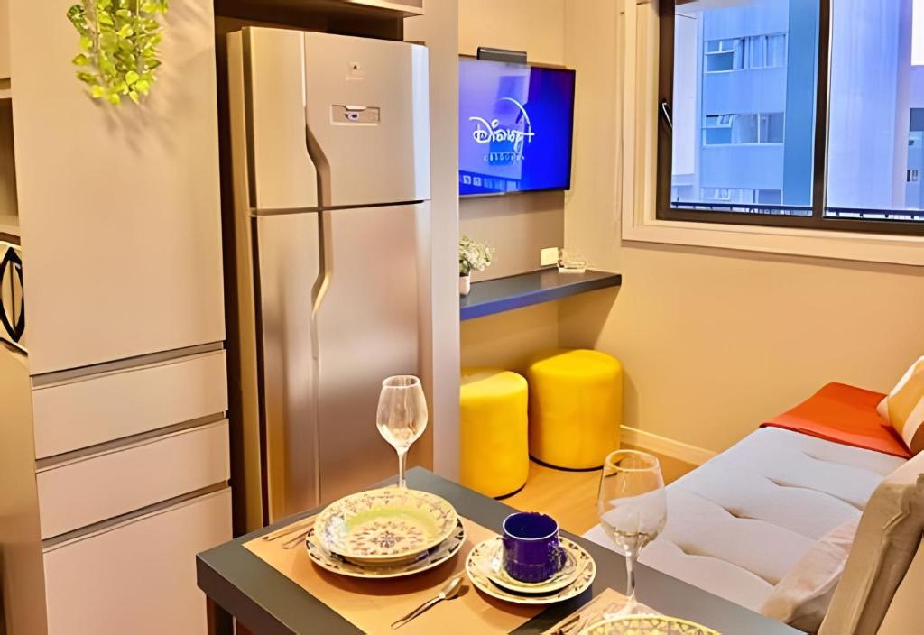 a room with a refrigerator and a table with wine glasses at #Luxuoso# Lindo e Moderno in Curitiba