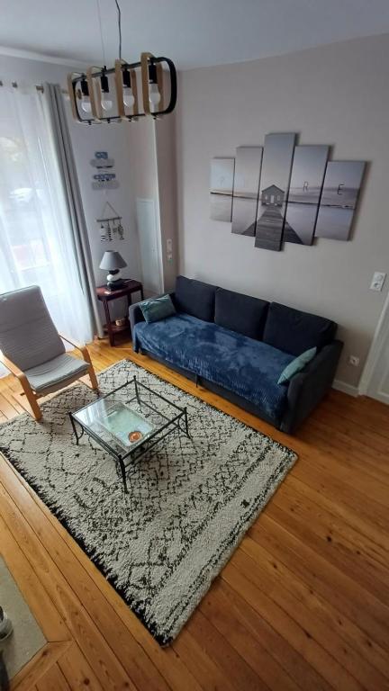 un salon avec un canapé bleu et une table dans l'établissement Le Saint Martin, à Fort-Mahon-Plage