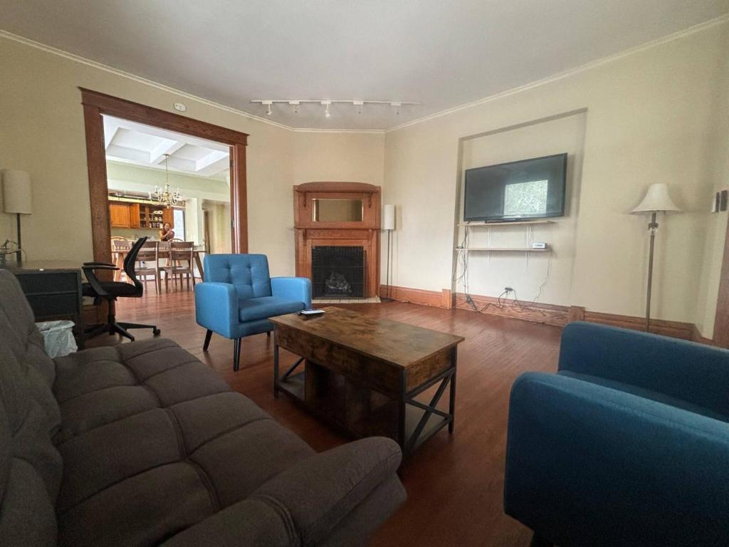 a living room with a couch and chairs and a fireplace at 2BR 1st floor suite close to ISU in Terre Haute