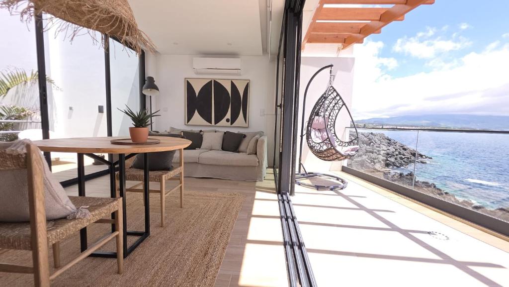 a living room with a table and a view of the ocean at Oasis House in São Roque