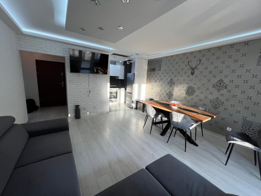 a living room with a wooden table and chairs at Miłe Miejsce in Inowrocław