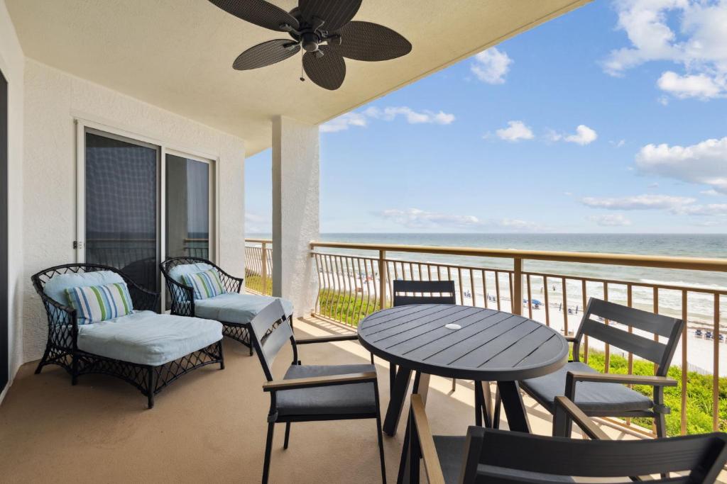 een balkon met een tafel en stoelen en de oceaan bij HP 24W Condo by 30A Escapes in Rosemary Beach