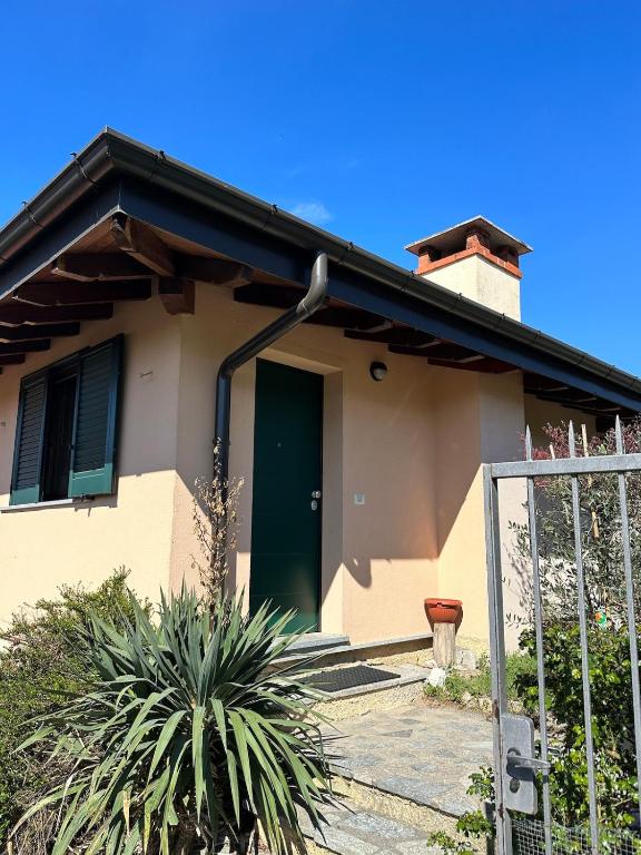 a house with a green door and a fence at Luisa Apartment, Lake Maggiore in Brezzo