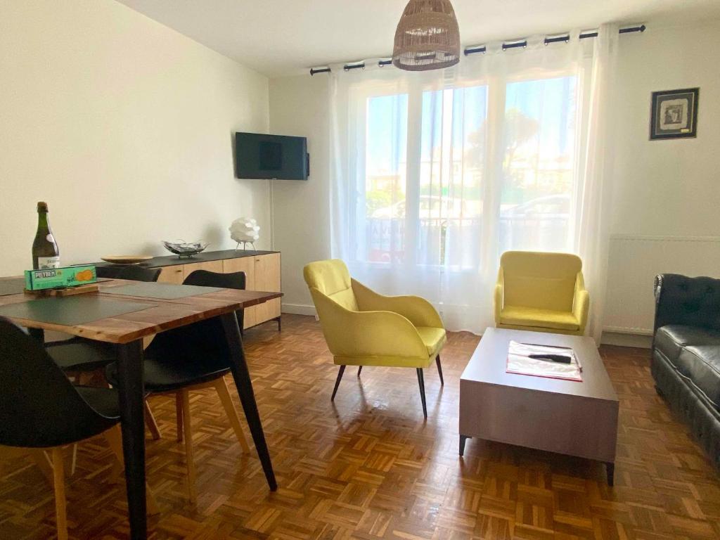 un salon avec une table et des chaises jaunes dans l'établissement Beau T3 à proximité du centre, 2 ch, 3 lits, à Brest