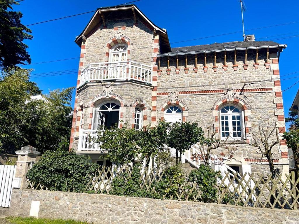 Un gran edificio de ladrillo con un balcón. en Villa bauloise d'exception plage Benoît, en La Baule