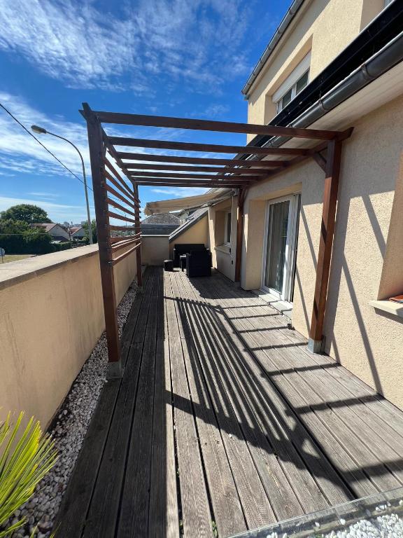 une terrasse en bois avec un auvent sur une maison dans l'établissement Maison spacieuse proche de Caen, à Colombelles