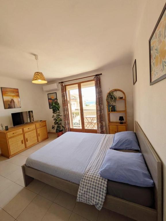 une chambre avec un grand lit et une fenêtre dans l'établissement Séjour à Valras T1 Vue sur Mer - 50m centre et mer, à Valras-Plage