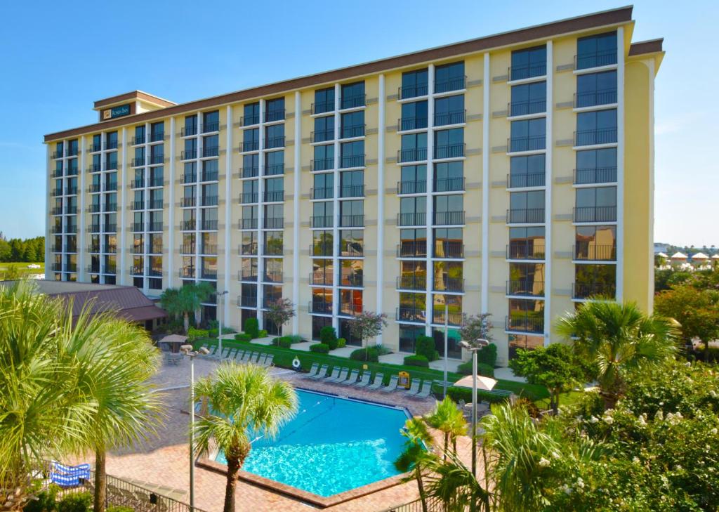 an aerial view of a hotel with a pool and palm trees at Rosen Inn Closest to Universal in Orlando