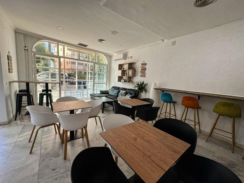 a restaurant with tables and chairs in a room at Hostel Sorolla Playa in Málaga
