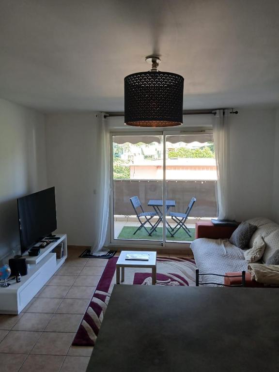 un salon avec un canapé et une télévision dans l'établissement Agréable T2, avec terrasse, à La Seyne-sur-Mer