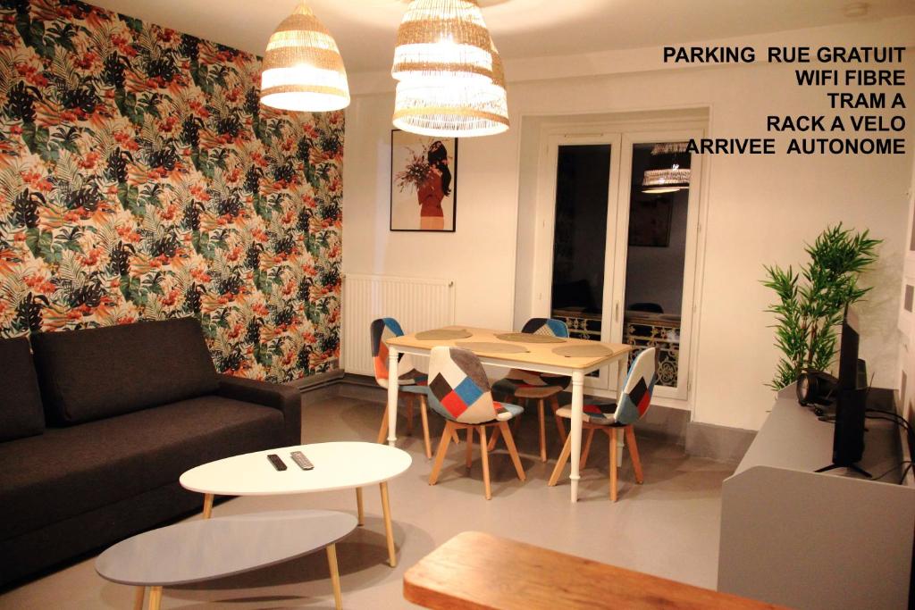 un salon avec un canapé, une table et des chaises dans l'établissement Tudelle Le T2 Coloré, à Orléans