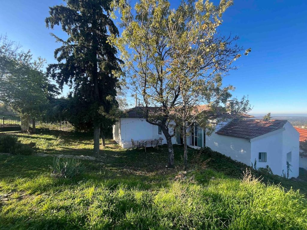 ein kleines weißes Haus auf einem Hügel mit Bäumen in der Unterkunft House in the Mountains of Toledo in San Pablo de los Montes