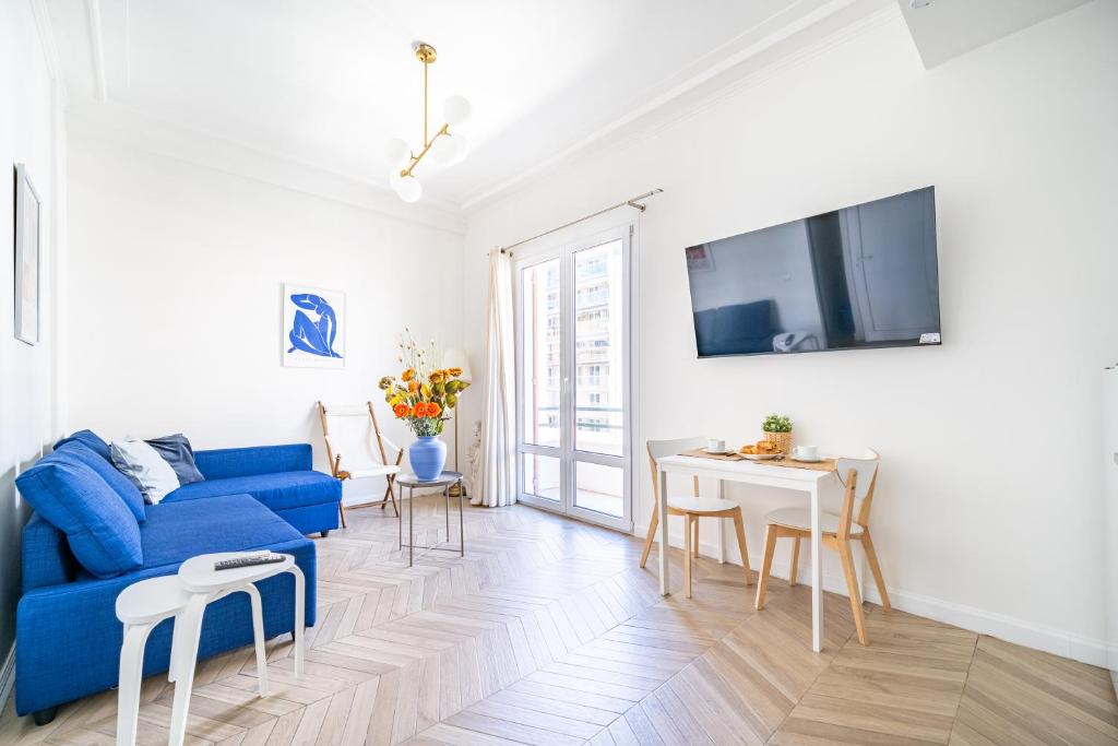 un salon avec un canapé bleu et une table dans l'établissement Studio moderne proche mer - Balcon et Climatisé, à Nice