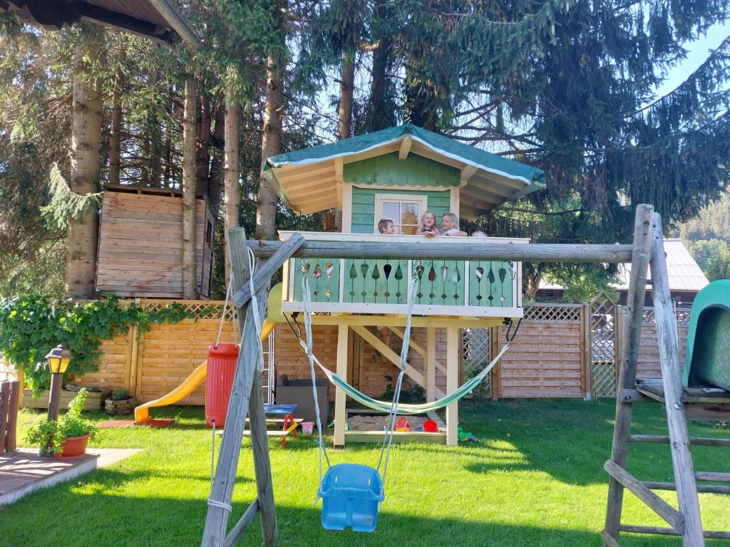 dwójka dzieci bawiących się w domu zabaw na podwórku w obiekcie Landhaus Tripolt w mieście Radstadt