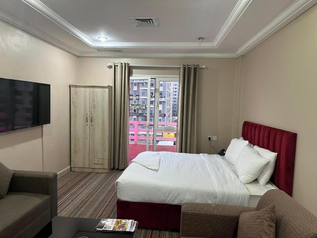 a hotel room with a bed and a couch at Pyramiza Fahaheel بيراميزا الفحيحيل in Kuwait