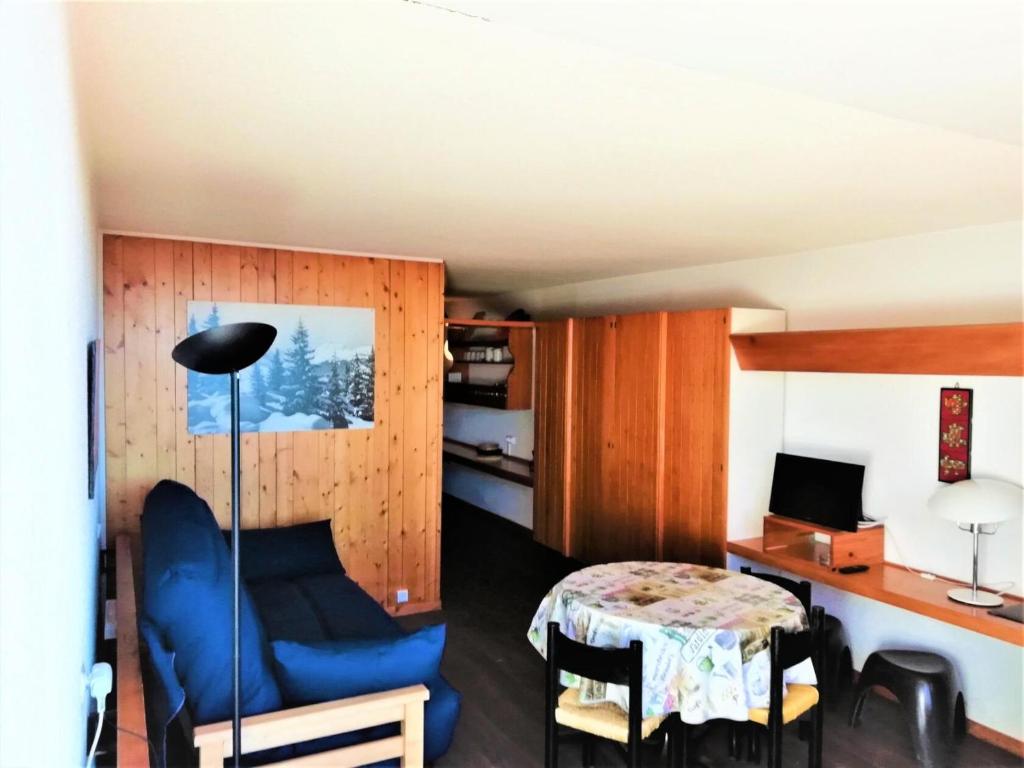 Cette petite chambre comprend une table et une chaise bleue. dans l'établissement Résidence Versant Sud - Studio 4 personnes à Arc 1600 dans une résidence proche des pistes et des commerces MAE-1824, à Arc 1600