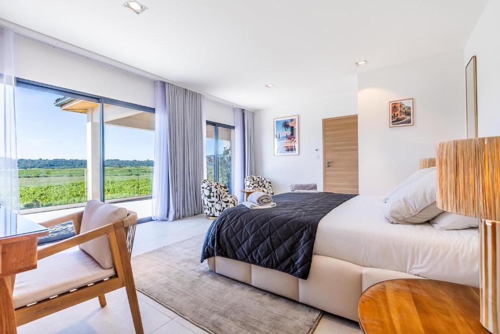 a bedroom with a bed and a desk and windows at Royal Tiki Lodges - Maison d'hôtes avec Piscine chauffée & SPA in Plaissan