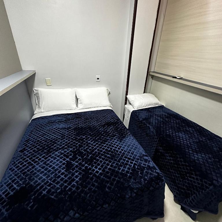 a small bedroom with a bed and a window at Loft Lux SM 07 (Smart TV, Ar condicionado, Cozinha) in Chapecó