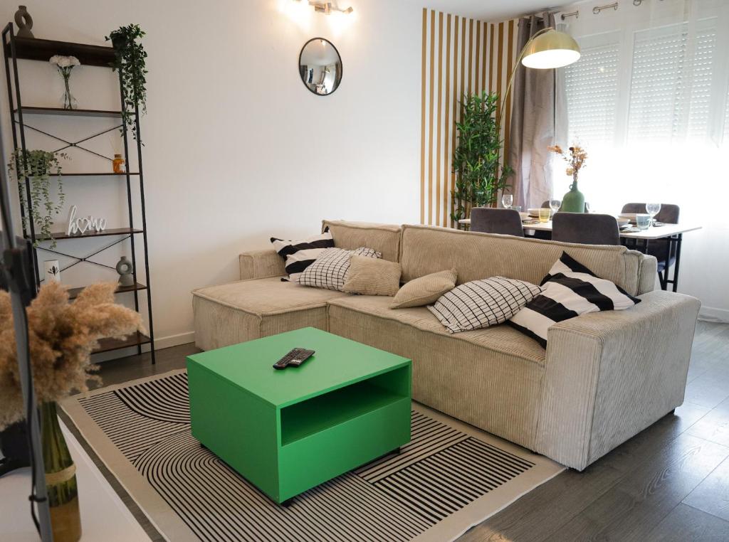 - un salon avec un canapé et une table verte dans l'établissement Charming 2 bedrooms free parking- near paris st lazare, à Argenteuil