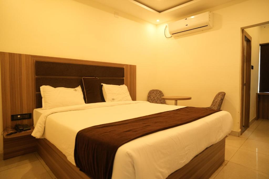 a bedroom with a large bed in a hotel room at 11 Leaf Hotel in Bhubaneshwar