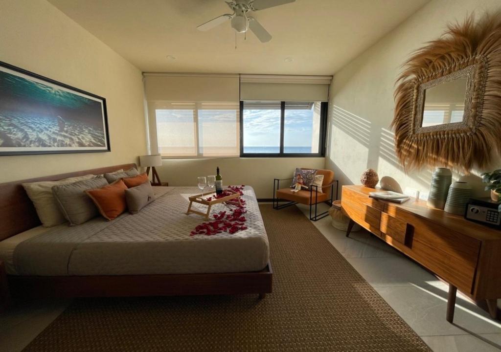 a bedroom with a bed and a table and a couch at Sunset 2BR Apartment Steps from the Beach with Ocean View in Holbox Island