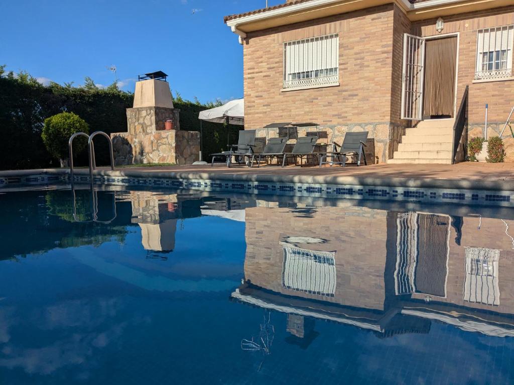 a pool of water in front of a house at Casa Alba in Escalona