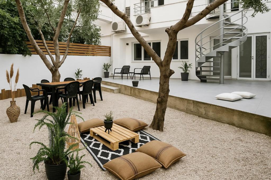 a patio with a table and chairs and trees at Sound of Vitality, Luxury Stay Near the Sea and Gym in Agios Nikolaos
