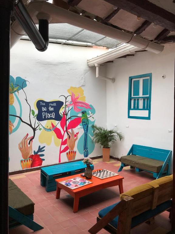 a room with a table and a wall with a mural at The Best Adventure Hostel in San Gil