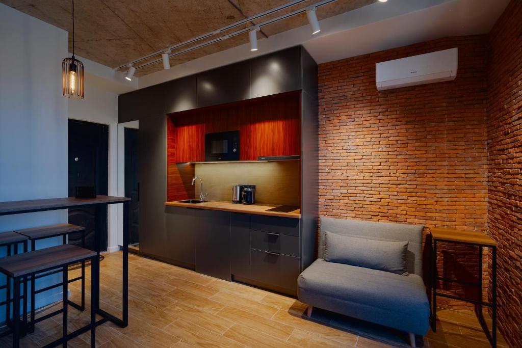 a living room with a couch and a brick wall at G-Point Sky Loft in Batumi