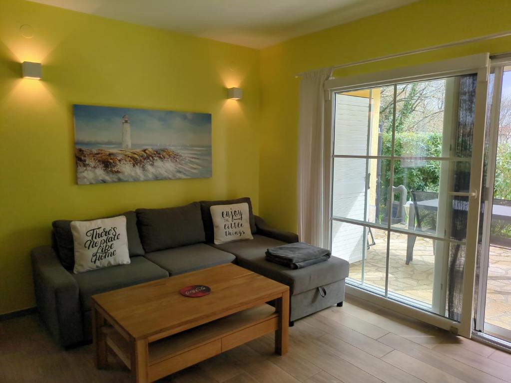 Villa Green Oasis في بوريتش: غرفة معيشة مع أريكة وطاولة