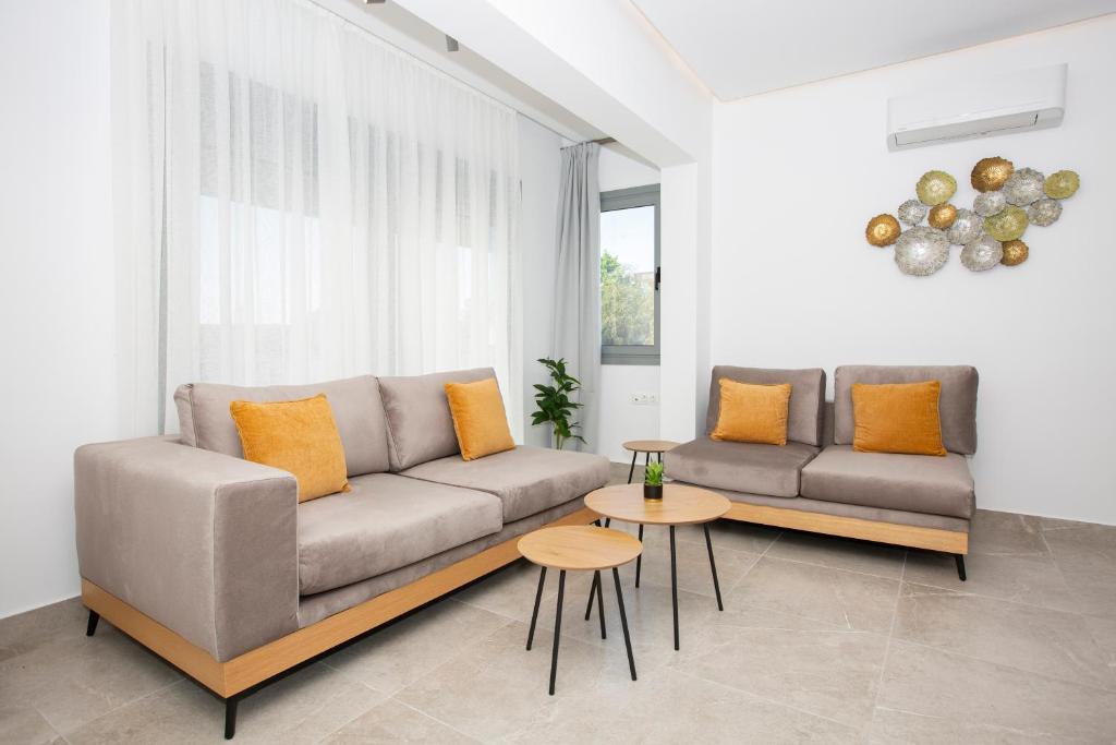 a living room with a couch and a table at RENI APARTMENT Faliraki in Faliraki