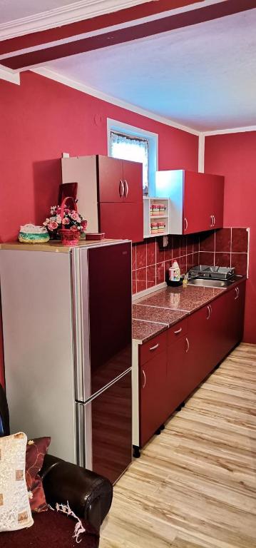 una cucina con armadi rossi e parete rossa di Vikendica Pavlović a Zatonje