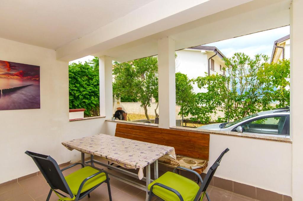un balcone con tavolo, sedie e auto di Apartment Kipson a Nin