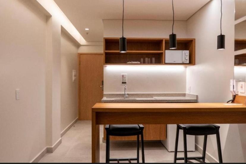 a kitchen with a counter and two stools at a table at Resort Premium Salinas in Salinópolis