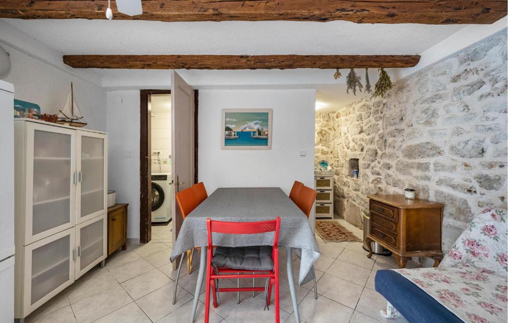 a dining room with a table and red chairs at Nice Home In Tisno With Wifi in Tisno