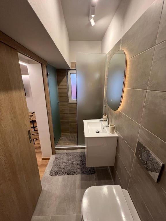 a bathroom with a toilet and a sink and a mirror at Imangination Home in Asprópirgos