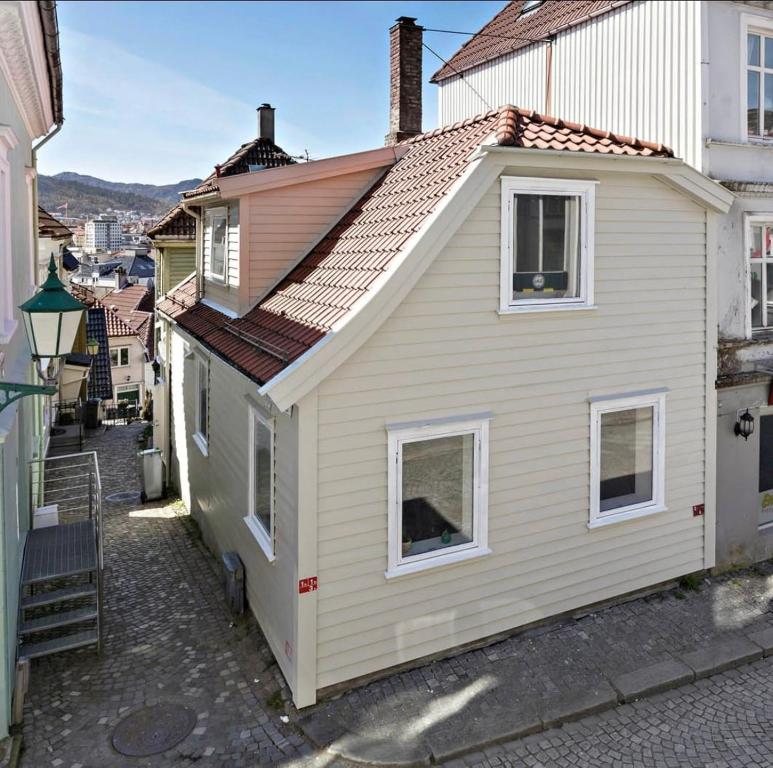une petite maison blanche avec un toit rouge dans l'établissement Hyggehuset, à Bergen