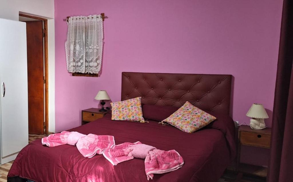 a purple bedroom with a bed with pink walls at Departamento Sol del Valle 1 in Fiambala